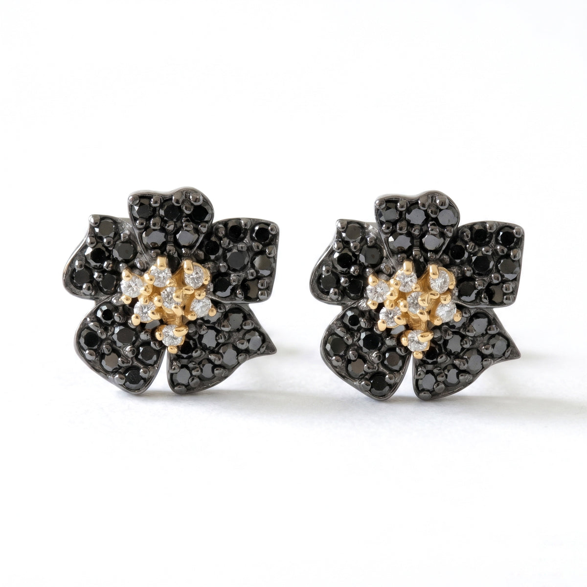 Enchanted Garden flower stud earrings in 18K two-tone gold with black and white diamonds, pair shown together