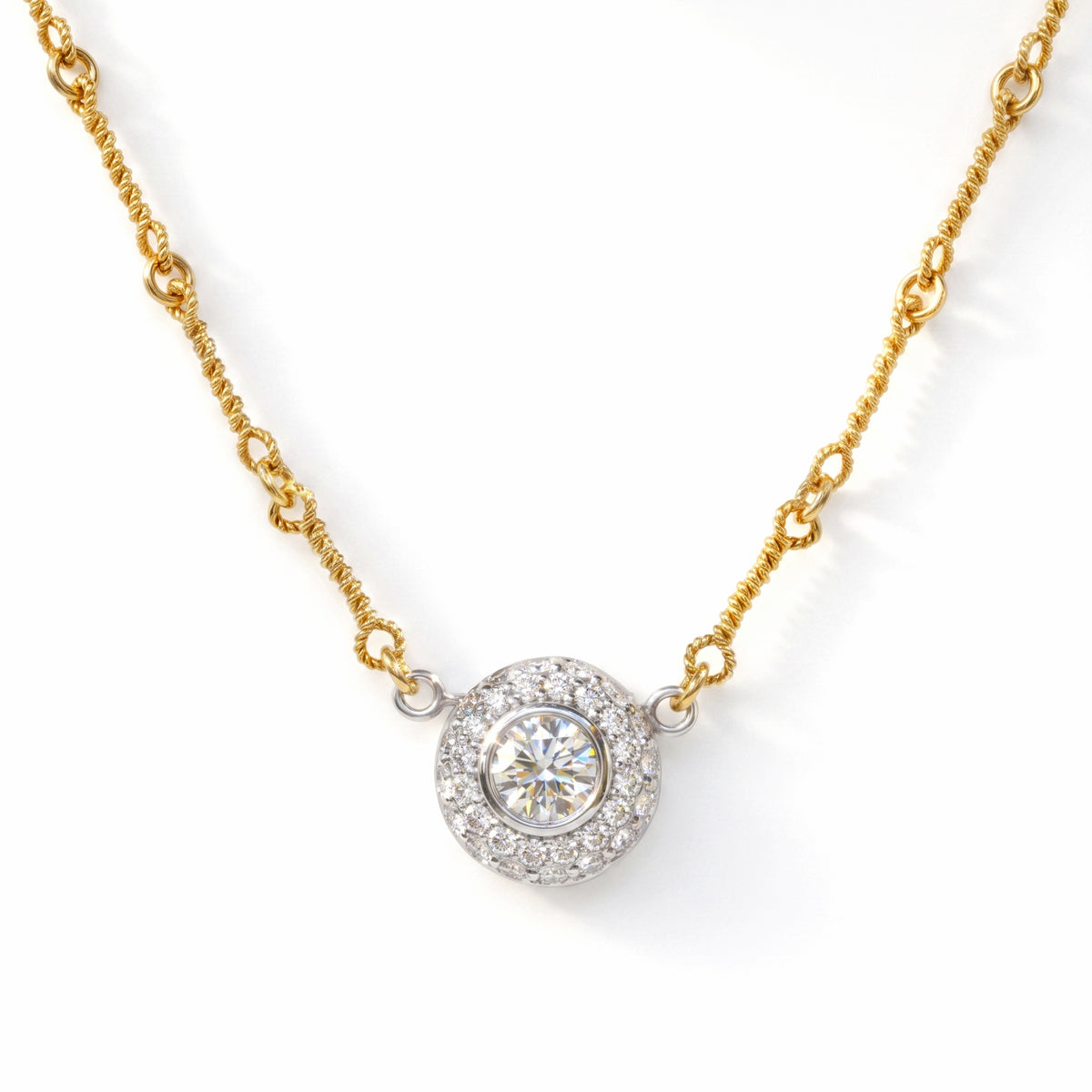 Diamond donut pendant necklace in 18K gold, close-up of the pendant on its twisted gold chain