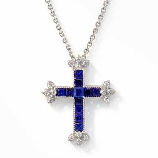 18K gold cross pendant with princess-cut blue sapphires and diamonds on a chain, front view