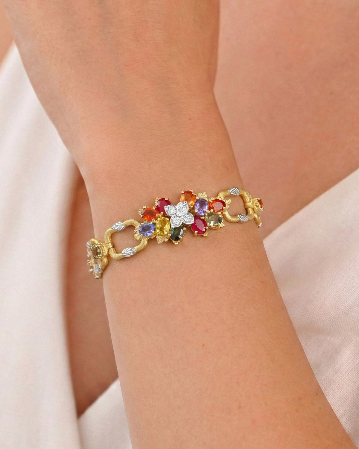 "Enchanted Garden" 18K two-tone gold multi-color sapphire and diamond bracelet, worn on the wrist