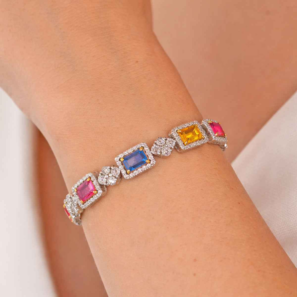 One of a kind multi color sapphire and diamond bracelet in 18K white gold, worn on the wrist