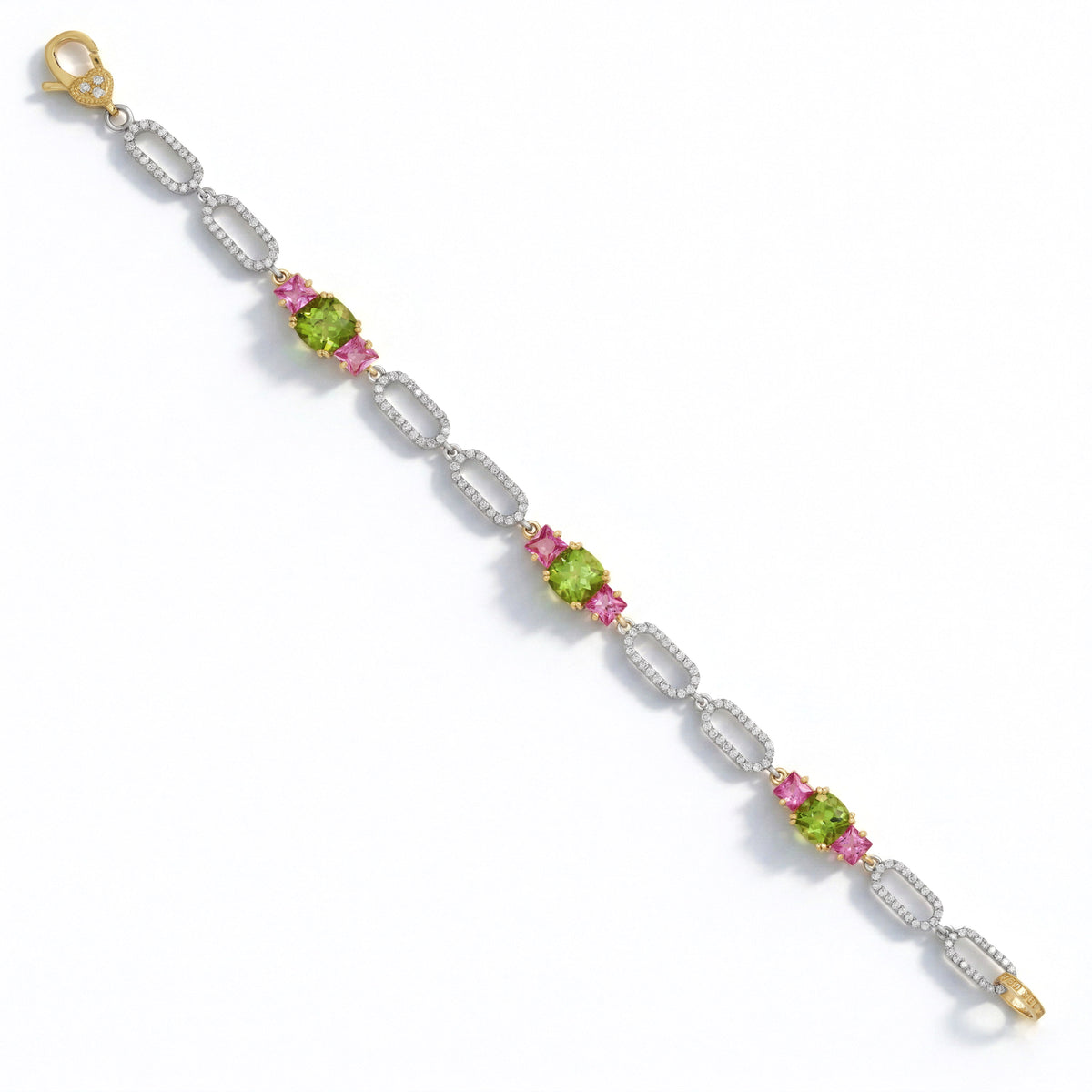Happiness peridot, pink sapphire and diamond link bracelet in 18K gold, laid out full length with clasp
