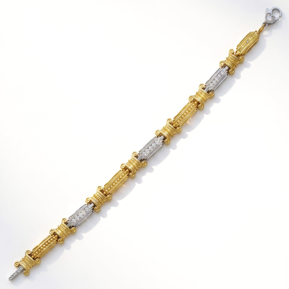 18K two-tone gold and diamond bracelet with yellow and white gold links, top-down view showing the clasp