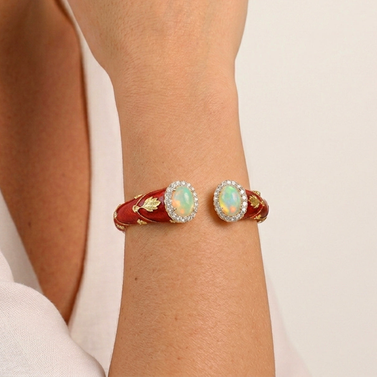 "Colors of Life" red enamel bracelet with opals and diamond halos in 18K gold, worn on the wrist