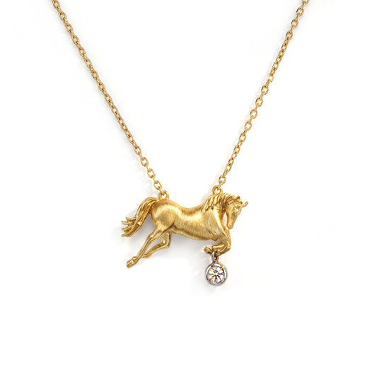 Equestrian horse charm pendant in 18K gold with a bezel-set diamond, shown with its chain