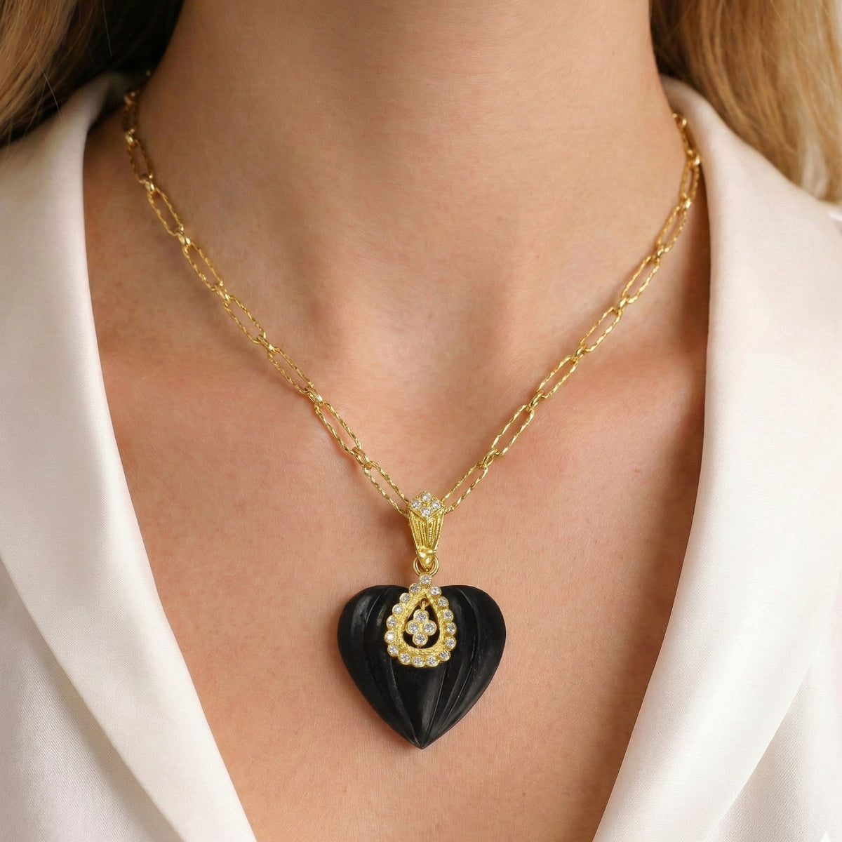 Candy frosted onyx heart enhancer pendant in 18K gold with diamonds, worn on a model