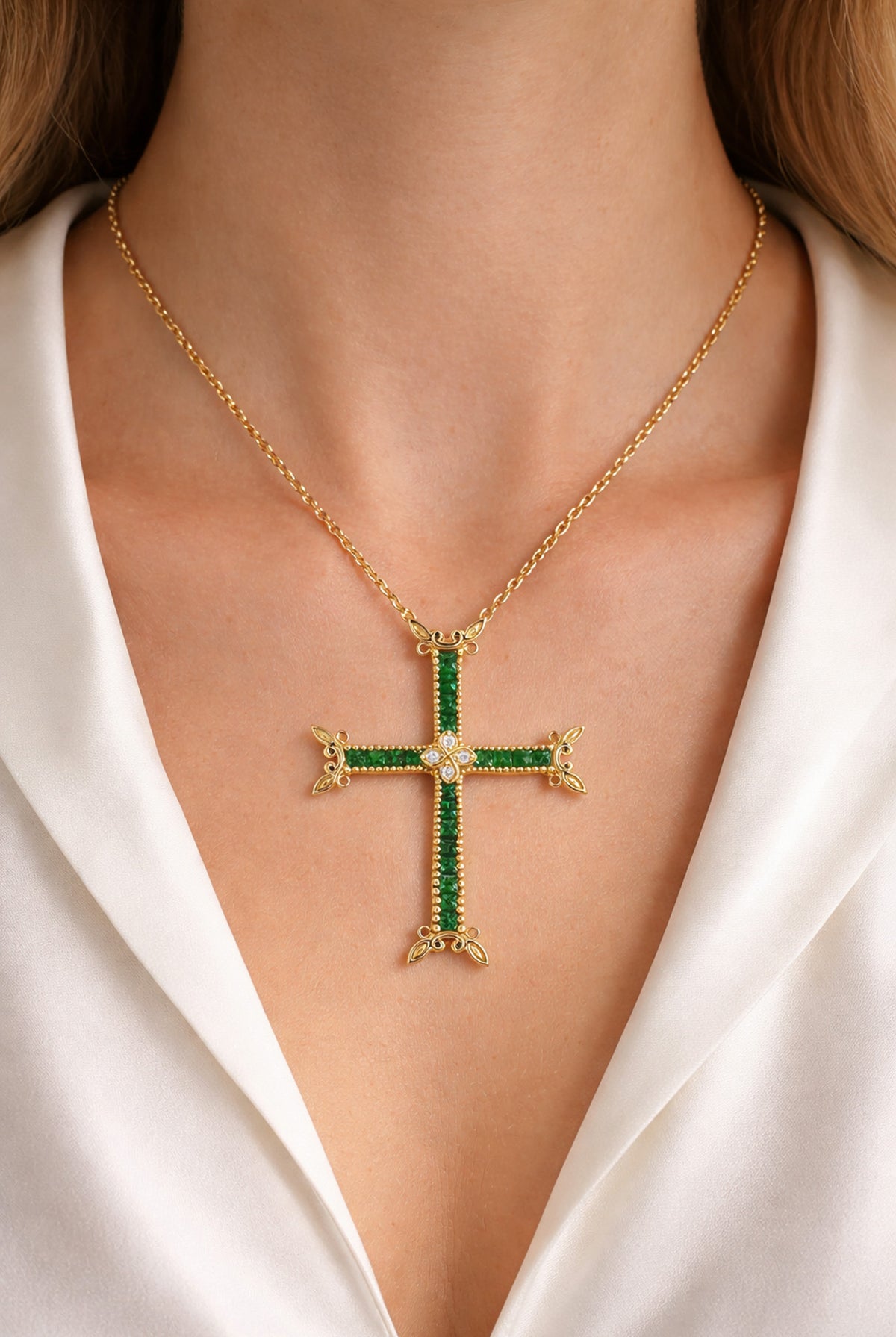 18K gold cross pendant with princess cut tsavorite garnets and diamonds, worn on a model