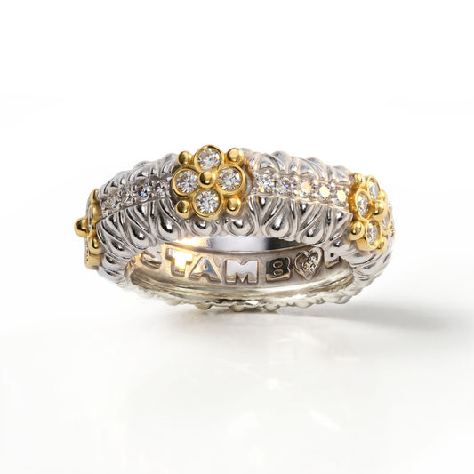 Diamond band ring in 18K two-tone white and yellow gold with floral accents, angled view of the band