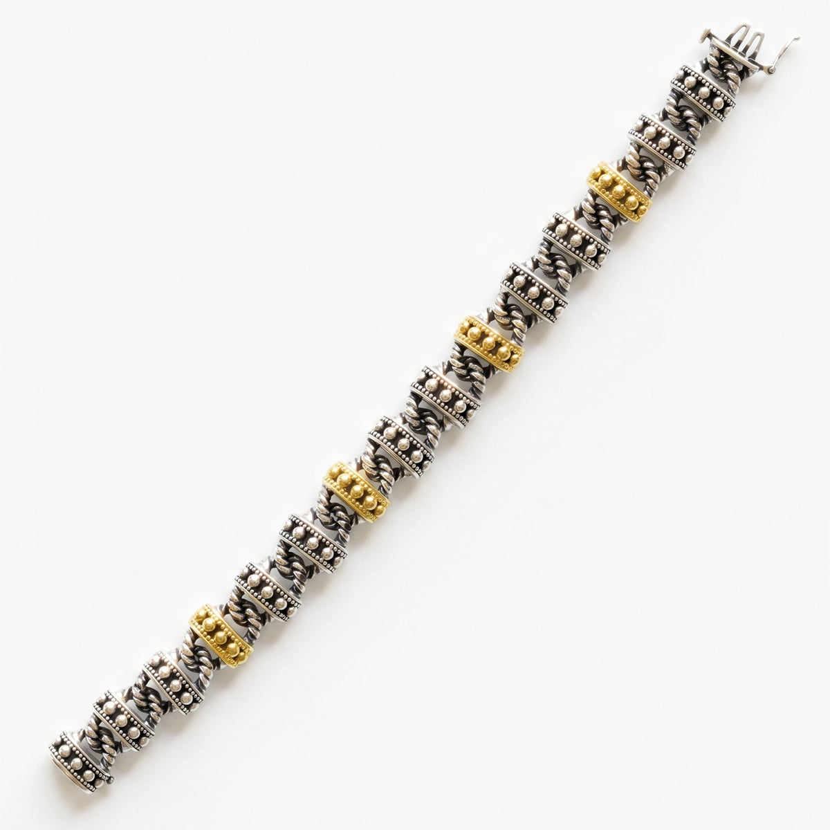 "Beginnings" unisex link bracelet in aged silver and 18K gold, laid out in a top-down view