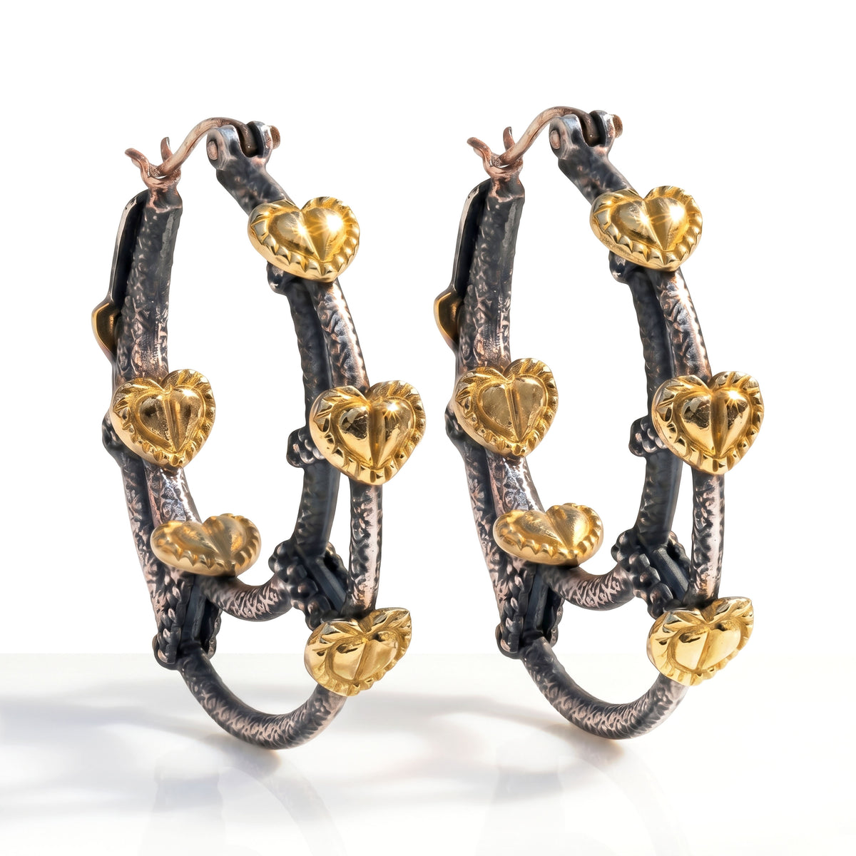 "Circle of Love" inside out heart hoop earrings in aged silver and 18K gold, pair shown together, angled view