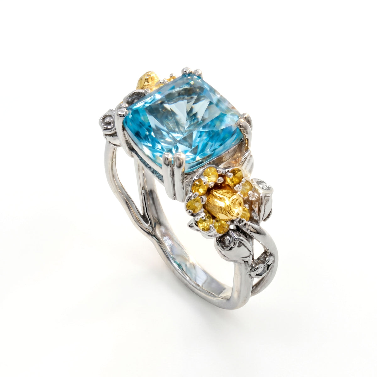 "Blossom" aged silver and 18K gold ring with blue topaz center and yellow sapphire flowers, angled view